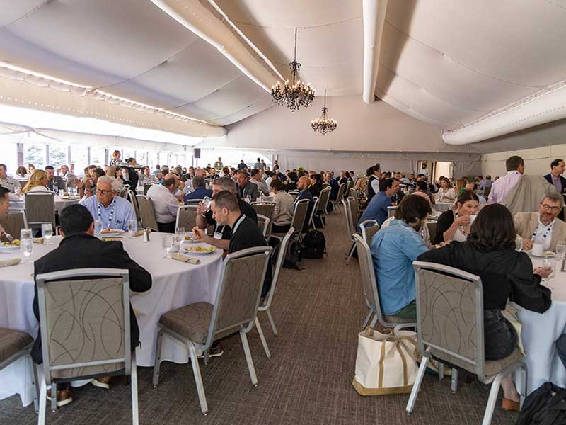 Attendees of the IFPA 2023 Retail Conference eat lunch in a large banquet room.