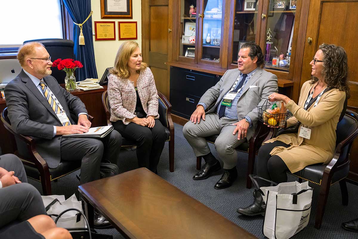 Two men and two women in a conversation in a private office during the Washington Conference.