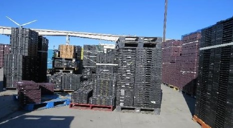 Reusable shipping containers stacked on a dock.